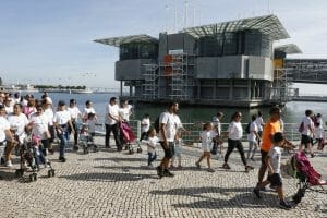 Participantes do Mimosa Passeio da Família a correr em frente ao Oceanário no Parque das Nações em Lisboa